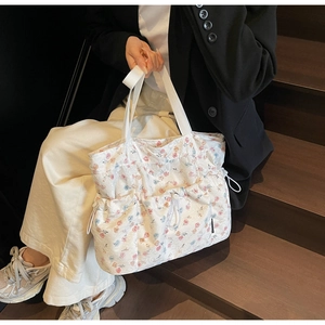 Detail view of floral tote bag with three drawstring pockets and wide canvas handles