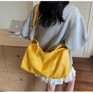 Detail of a bright yellow tote bag with love 105 embossed text on the front