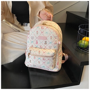 Close-up of pink floral cartoon bear backpack with heart patterns and gold zipper detail