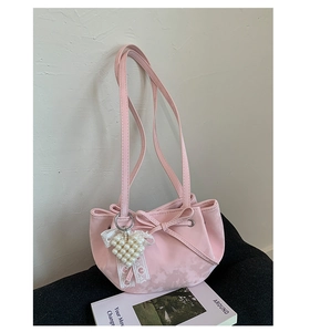 Detail of pink bow shoulder bag with heart pearl pendant and ruched top closure
