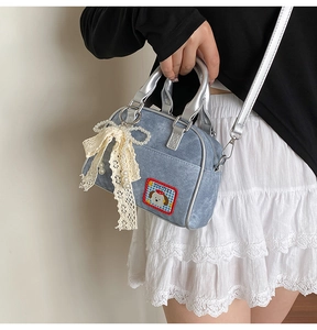 Détail du sac à main en jean avec écusson de chien et nœud en dentelle et perles