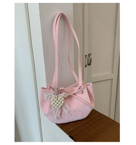 Pink faux leather shoulder bag with a pearl heart charm and elegant ribbon detail