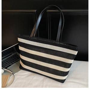 Detalle de la textura tejida de un bolso tote grande a rayas blancas y negras
