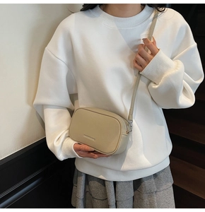 Détail d'un sac bandoulière beige en cuir grainé avec une bandoulière réglable