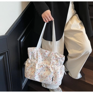 Detail of floral tote bag showing pleated drawstring texture and white canvas strap