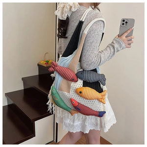 Detail view of woven crochet tote bag featuring colorful hanging fish dolls and fringe