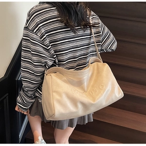 Detailed top-down shot of a beige large tote bag with embossed 105°C logo on leather
