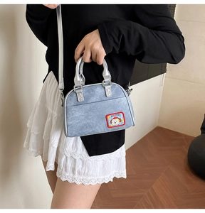 Détail du sac à main en denim avec broderie chiot mignon et poignée supérieure argentée