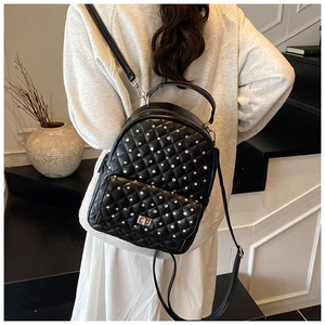 Dettaglio zaino nero in pelle trapuntata con strass scintillanti e chiusura a girello in metallo