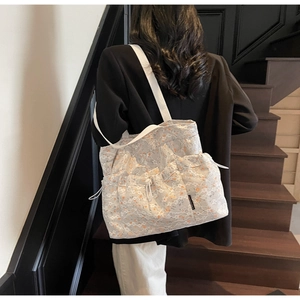 Detailed shot of large floral lace tote bag featuring drawstring pockets and canvas straps