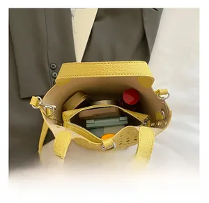 Vue détaillée de la capacité du sac seau ajouré jaune avec sa pochette intérieure assortie