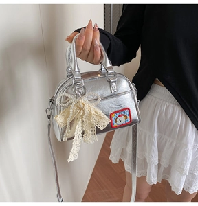 Détail du sac à main en PU argenté avec breloque papillon en dentelle et broderie