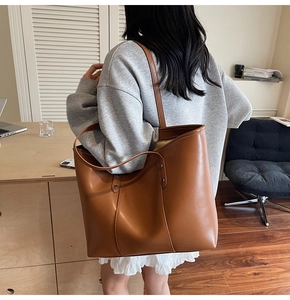 Detailopname van een grote bruine shopper met vintage textuur en reliëf branding