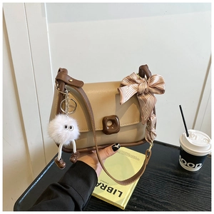 Detail of crossbody bag with beige scarf handle, plush pendant and square turn-lock closure