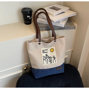 Close-up of contrast canvas tote bag with embroidered quote on a chic interior background