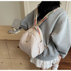 Dettaglio dello zaino leggero beige con spallacci in tessuto con motivi etnici colorati