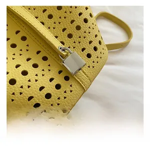 Détails du sac seau jaune ajouré au laser avec motifs géométriques et fermoir argenté