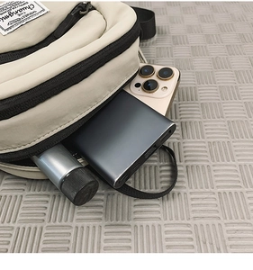 Internal view of beige canvas crossbody bag showing storage space for phone and power bank