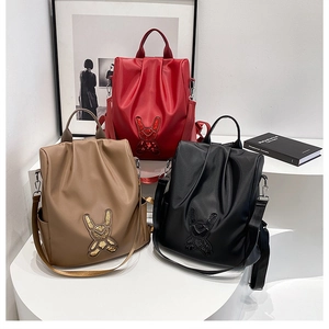 Detailed comparison of red, khaki and black nylon backpacks with sequined rabbit patches