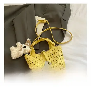 Détail du sac seau jaune ajouré avec fermoir argenté et breloque petit ours