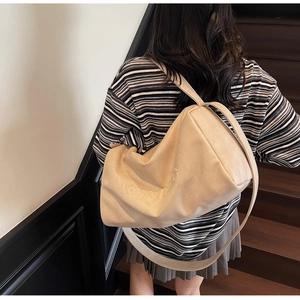 Detail of beige leather hobo bag with love embossing and wide shoulder strap