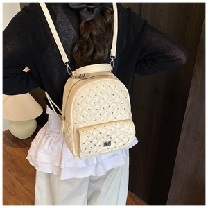 Dettaglio mini zaino trapuntato bianco crema con strass indossato da una modella
