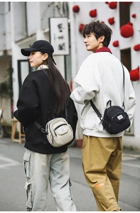 Close-up of minimalist nylon crossbody bags in black and beige with adjustable straps