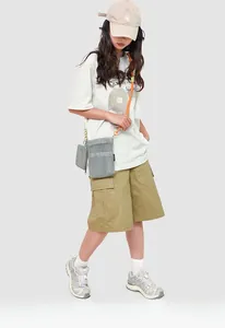 Grey mesh crossbody bag with vibrant orange rope strap shown on a fashion model