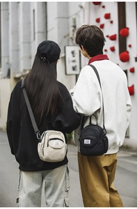 Urban lifestyle view of minimalist nylon crossbody bags in beige and black with straps