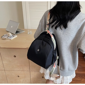 Dettaglio mini zaino nero con tracolla larga a motivi geometrici colorati in stile etnico