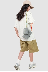 Grey mesh crossbody bag set with bold rope strap shown in a city outdoor style outfit