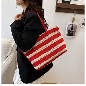 Detalle del bolso tote tejido a rayas rojas y blancas con correas rojas para el hombro