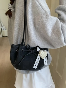 Fashionable black suede shoulder bag with ribbon bow and pearl heart charm accessory