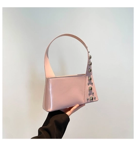 Detail of pink glossy shoulder bag with silver metallic studs in a geometric design