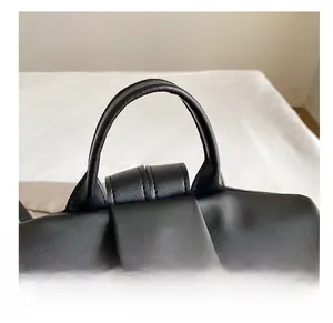 Close-up of durable black nylon material with reinforced leather handle and stitching