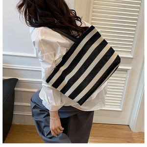 Bolso tote de tejido a rayas con asas de cuero llevado al hombro para ver el tamaño
