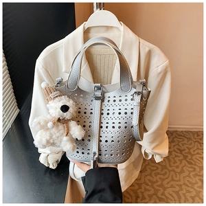 Détail du sac seau argenté découpé au laser avec texture métallique et pendentif ours