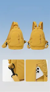 Detail of yellow nylon backpack showing convertible straps and hidden anti-theft back pocket