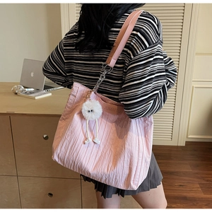 Dettaglio della borsa tote plissettata rosa con ciondolo in peluche e finiture in argento