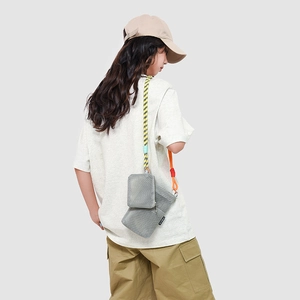 Detail view of grey mesh crossbody bag set with colorful woven rope shoulder straps