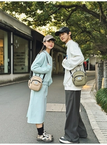 Outdoor street style view of casual beige and green waterproof nylon crossbody bags