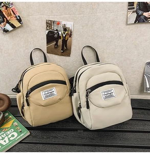 Mini nylon backpacks in khaki and beige with multi-zipper layers and top handles