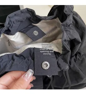 Detail view of the black nylon bag featuring an invisible magnetic closure and interior pocket