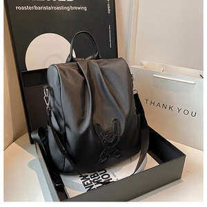 Detail of black leather backpack featuring sequined rabbit design and adjustable straps
