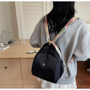 Dettaglio dello zaino in nylon nero con spallacci larghi ricamati in stile etnico