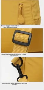 Detail view of the yellow backpack showing brand zipper, adjustable buckle, and D-ring hook