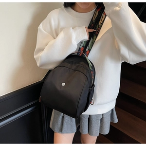 Dettaglio mini zaino in nylon nero con tracolla intrecciata etnica e colorata