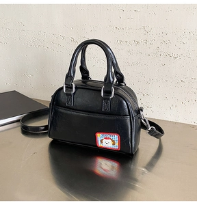 Détail du sac bowling noir en similicuir avec un écusson brodé de chien mignon