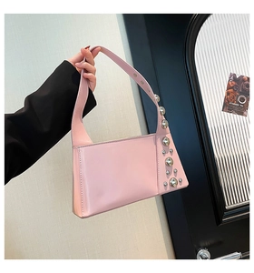 Close-up of pink rivet shoulder bag with silver studs and wide strap detail