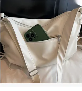 Détail du sac demi-lune blanc en PU avec poche zippée et espace pour téléphone portable